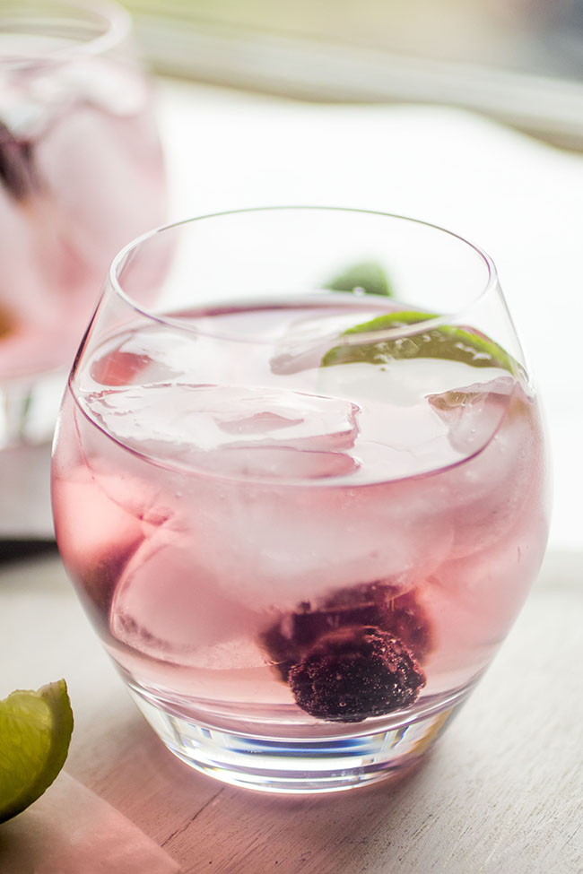 Blackberry vodka tonic garnished with fresh blackberries and a lime wedge.
