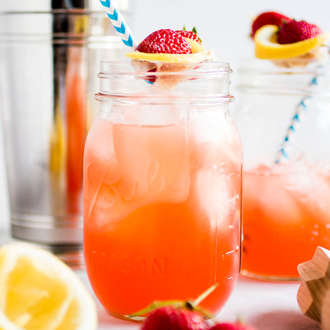 Strawberry whiskey lemonade in glass mason jars.